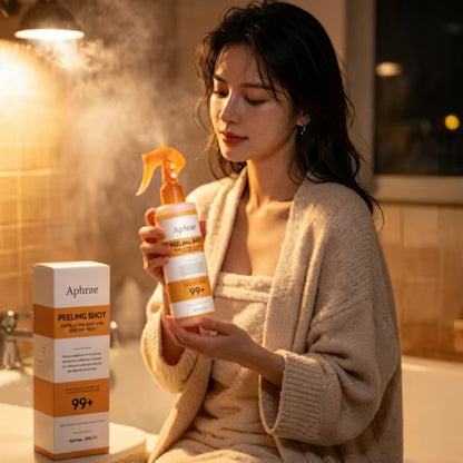 Woman in a cream robe holding Golden Peel Shot in a steamy bathroom, warm light behind her